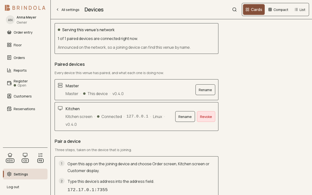 The devices settings screen: the venue network being served, the main device and a paired kitchen screen that is connected. · shown in English
